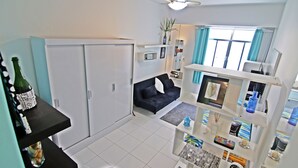 A compact living space with a sofa, a dining table, and a ceiling fan. - Rio Spot Apartment C019 (Rio de Janeiro)