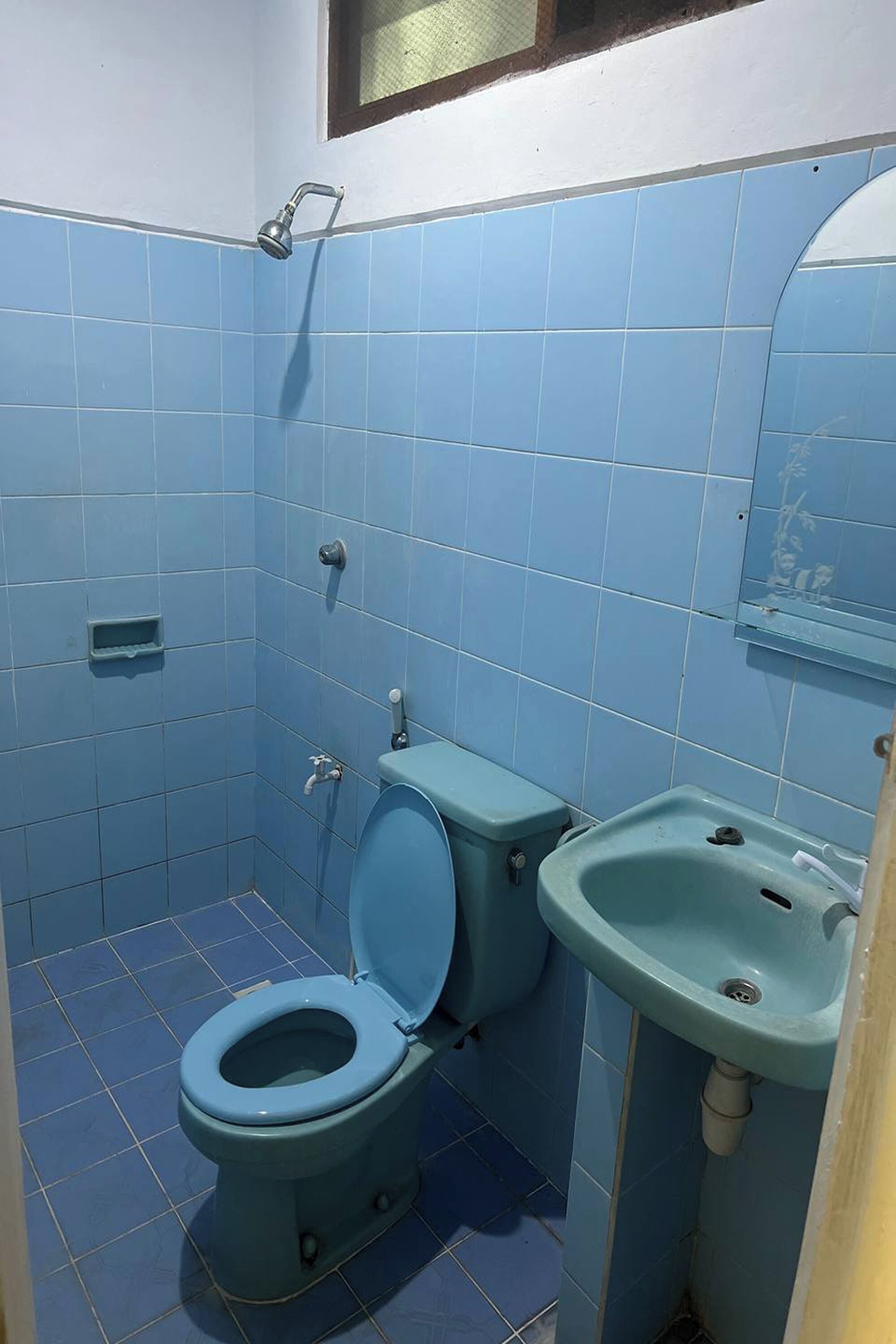 A bathroom with a toilet, sink, and shower.