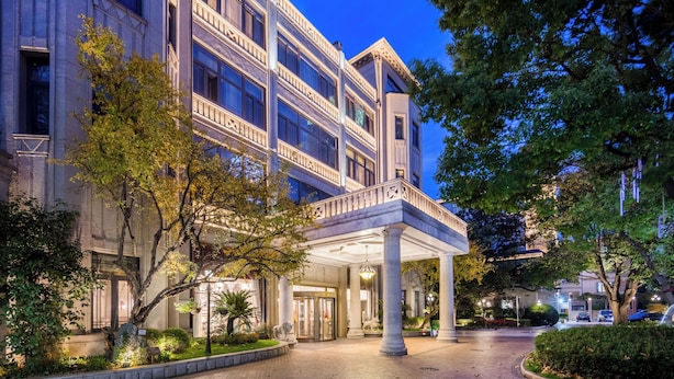 A multi-story building with a grand entrance, columns, and a covered area. - Shanghai Donghu Hotel (Shanghai)