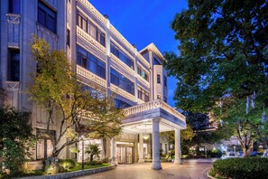A multi-story building with a grand entrance, columns, and a covered area. - Shanghai Donghu Hotel (Shanghai)