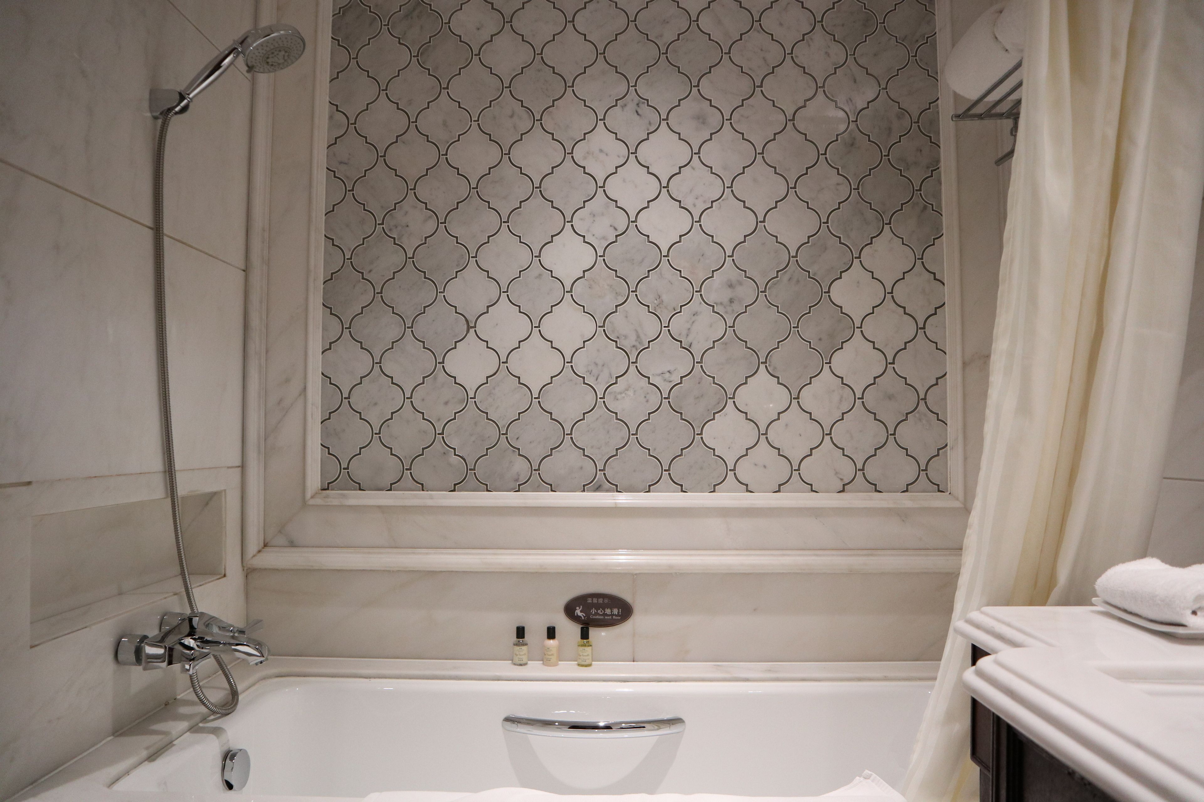 A bathroom with a shower, a bathtub, and a vanity with a towel.