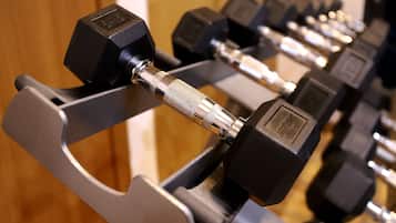 A rack of black dumbbells with silver handles and weight markings.