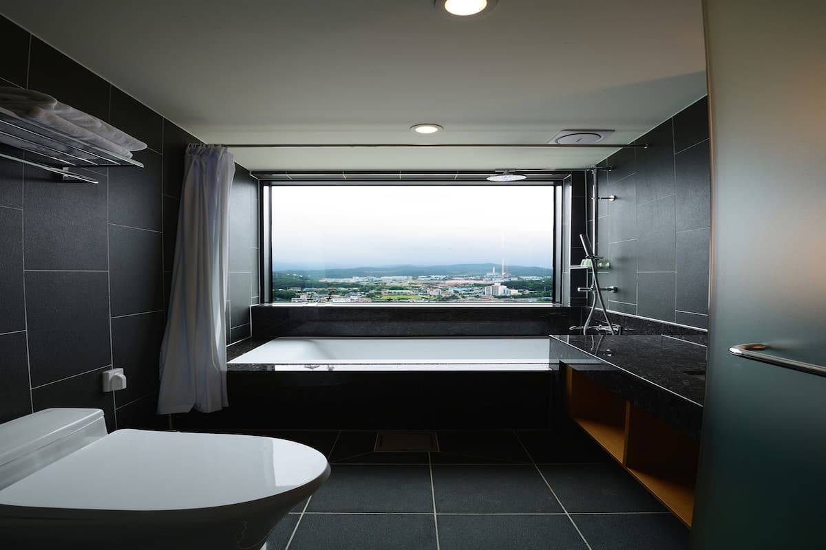 executive suite | bathroom | hair dryer, slippers, bidet, towels