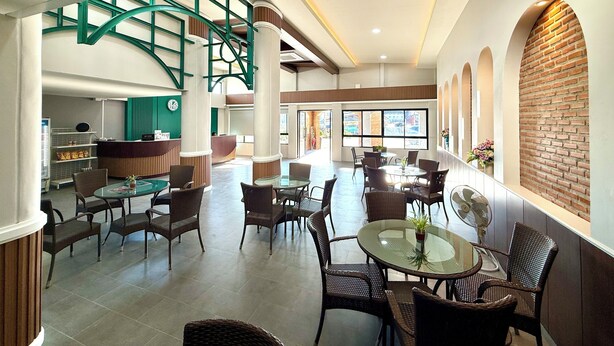 A spacious lobby with a central staircase, multiple seating areas, and a reception desk. - KYP Hotel (Fang)