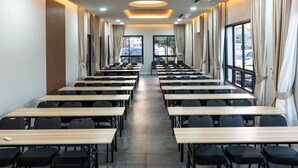 A long, well-lit conference room with rows of tables and chairs, large windows, and a modern ceiling design. - KYP Hotel (Fang)