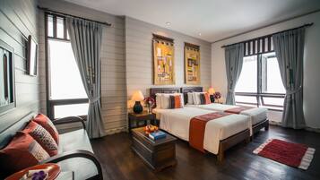 Una habitación de hotel con una cama grande, dos mesitas de noche, un escritorio y una silla.