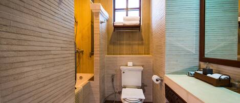 A compact bathroom with a toilet, sink, and shower.