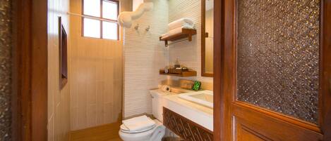 Un baño con inodoro, lavabo y ducha.