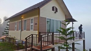 A two-story building with a balcony, large windows, and a small porch area. - Byemuang Khaokho Resort View Talaymok (Khao Kho)