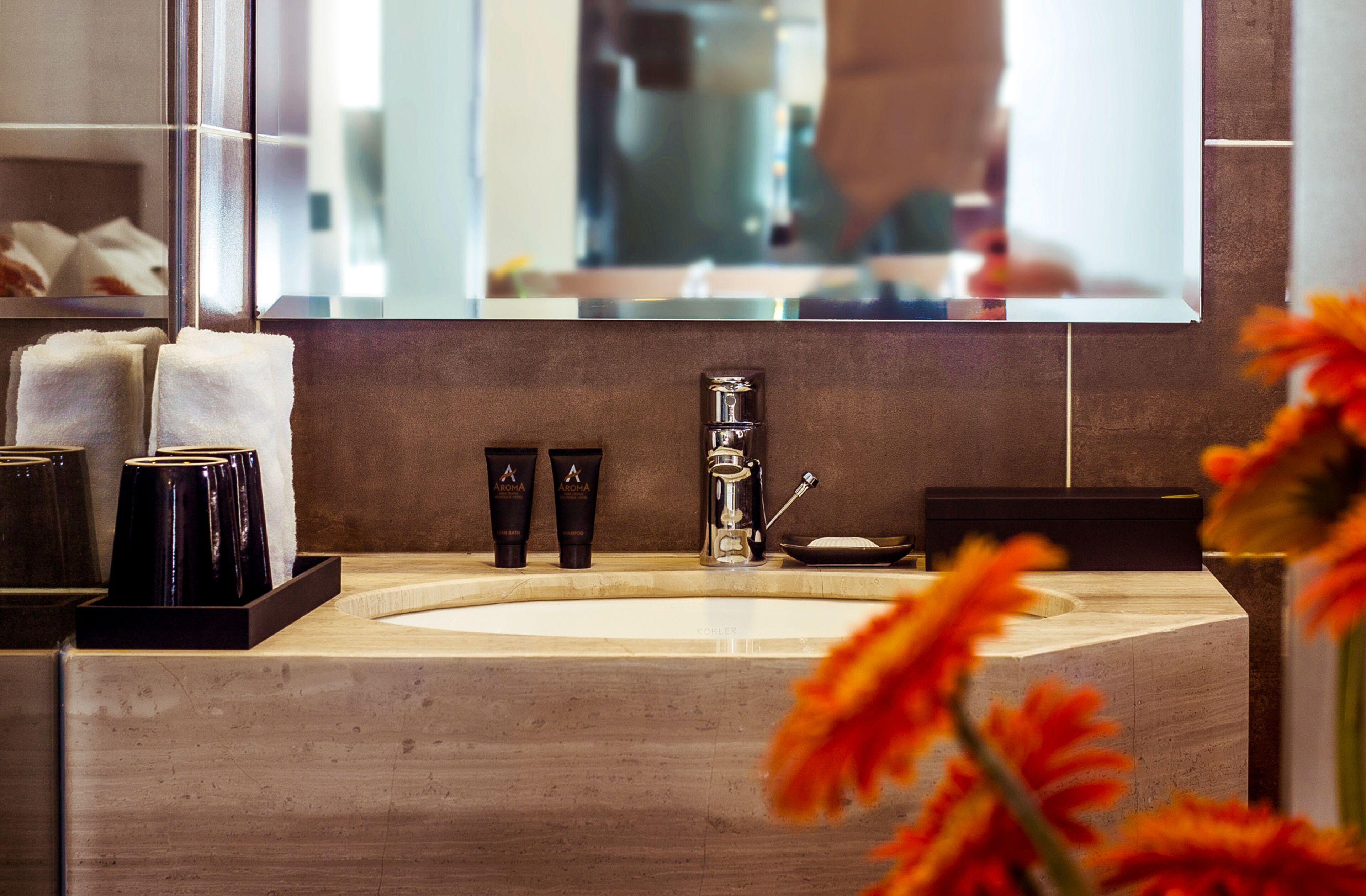 A bathroom with a large sink, a mirror, and toiletries.