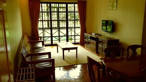 Una sala de estar con un sofá, una mesa de centro, un televisor y una mesa de comedor.
