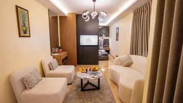 Deluxe Suite with Spa Bath | Khu phòng khách | TV LED 32-inch có truyền hình vệ tinh, TV, sách