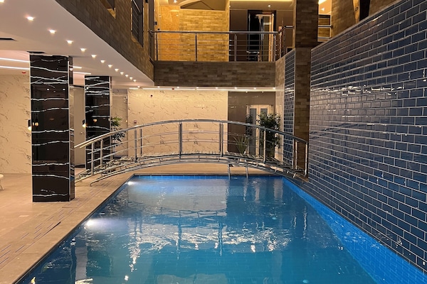 En säsongsöppen utomhuspool och solstolar