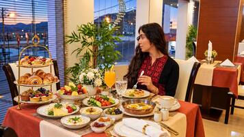 A dining table set with a variety of dishes, including pastries, fruits, and a beverage.
