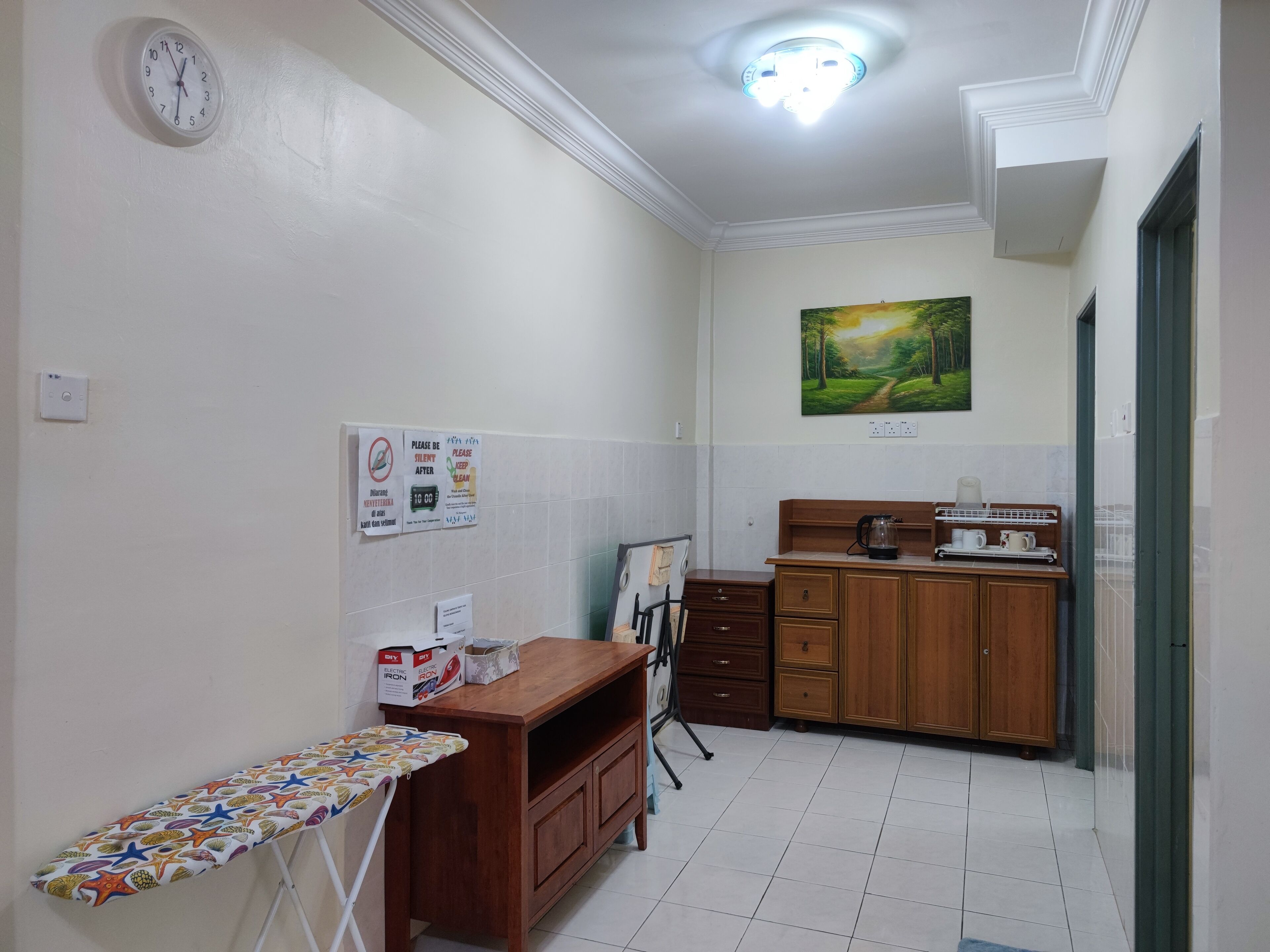 Una cocina pequeña y bien iluminada con una encimera de madera, una cafetera y un cuadro en la pared.