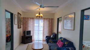 A living room with a television, sofa, and a ceiling fan. - KPW at Royal Lily Apartment (Tanah Rata)