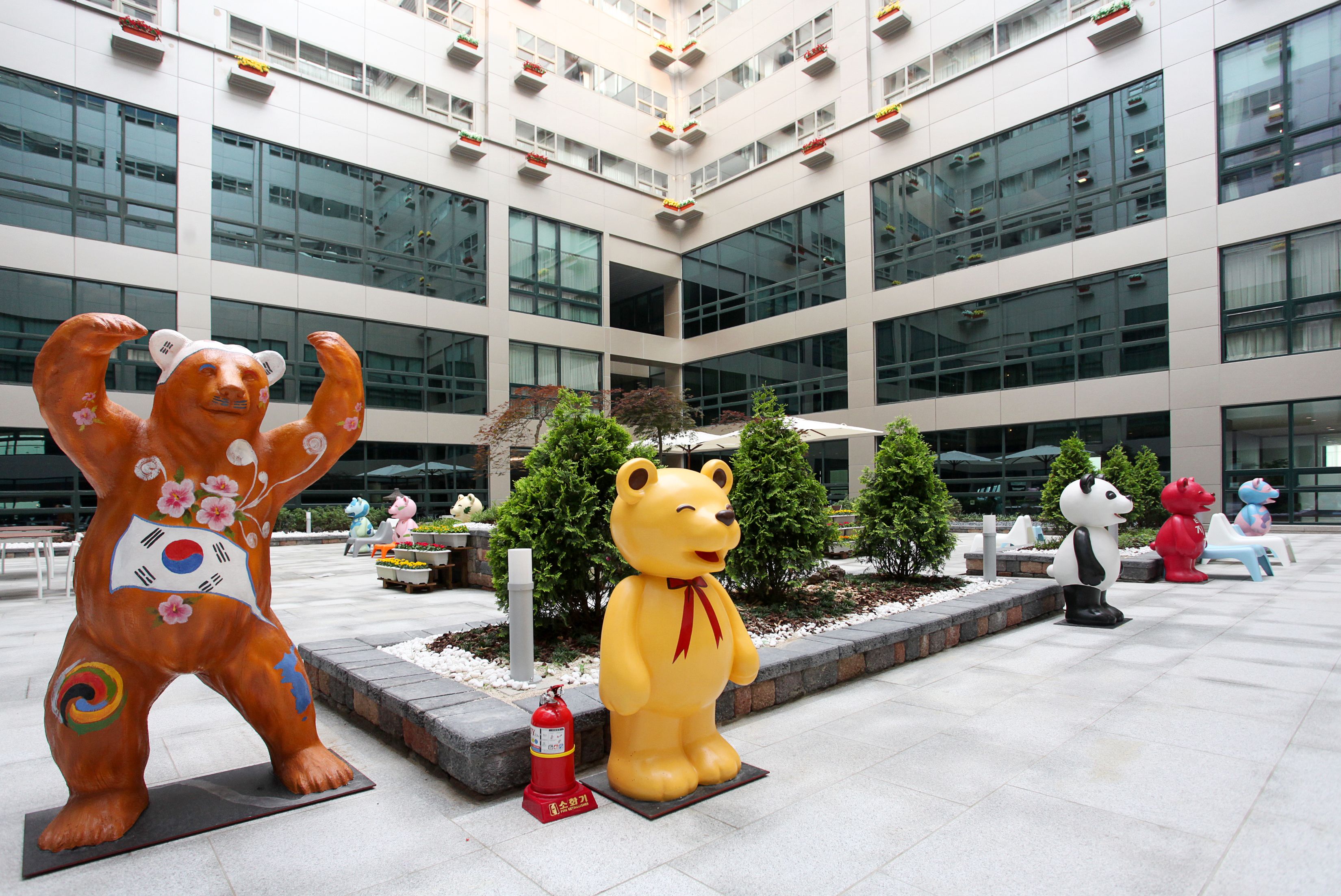 Eine große Bear-Statue vor einem modernen Gebäude mit mehreren Stockwerken und großen Fenstern.