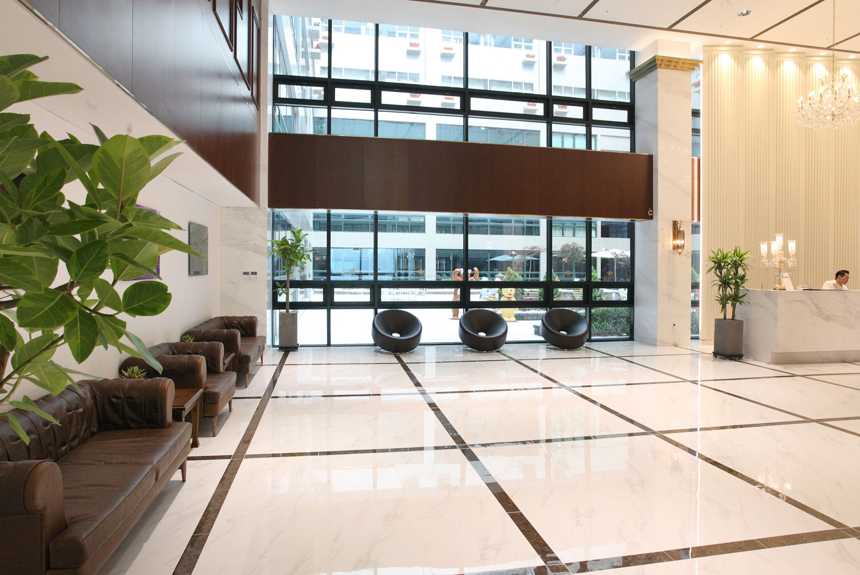 Una hall moderna con area salotto, ampie finestre e reception.