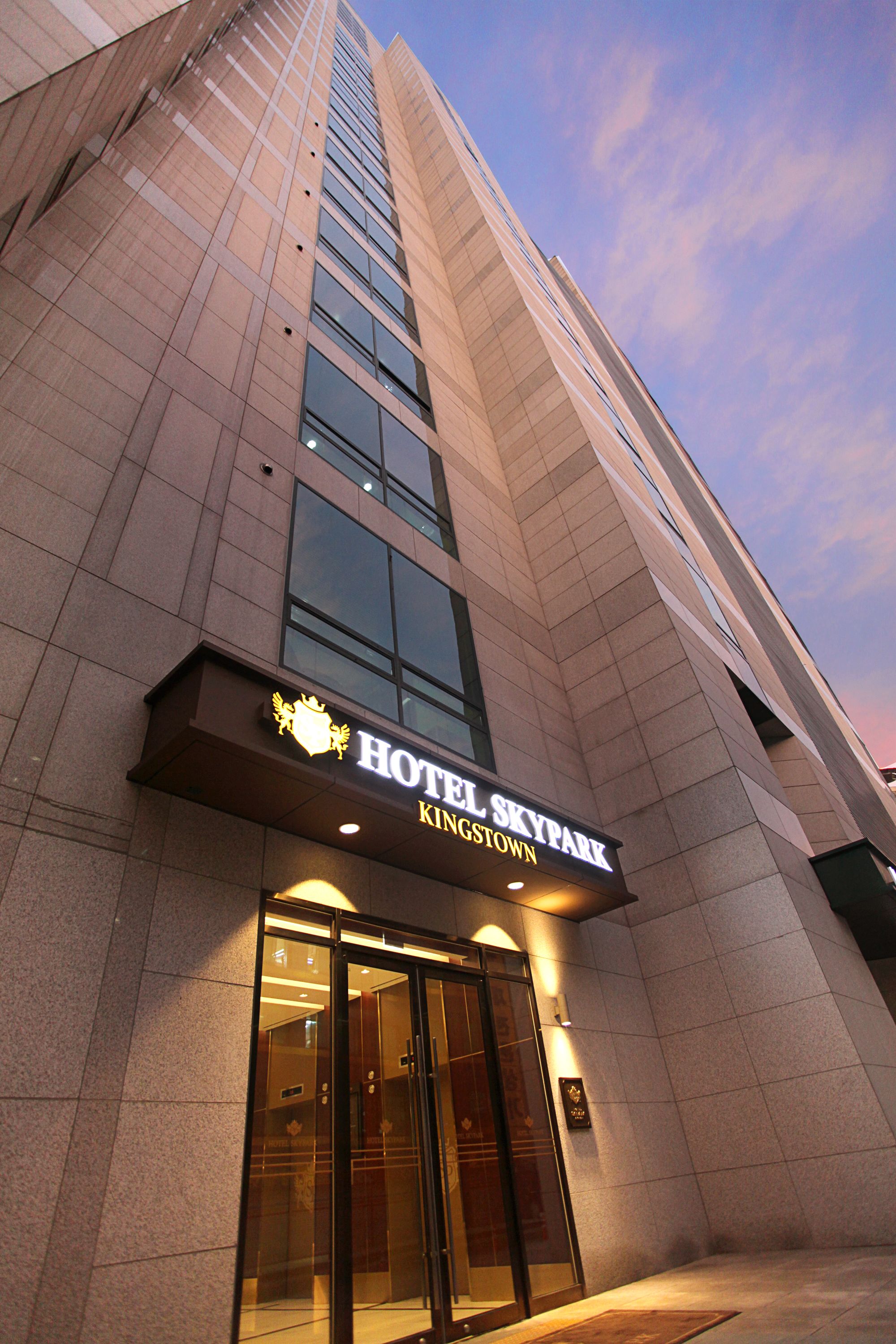 L’extérieur de l’hôtel Skylark Kingstown présente un design moderne, avec une entrée imposante et de grandes fenêtres.