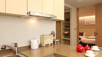 A modern kitchen with a stainless steel sink, a coffee machine, and a small wooden box labeled "Coffee & Tea".