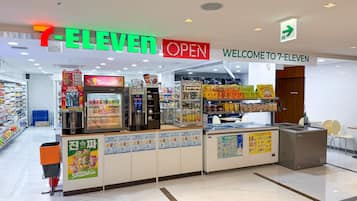 Una tienda de conveniencia 7-Eleven con una amplia variedad de alimentos y bebidas, incluyendo una máquina para batidos y vitrinas refrigeradas.