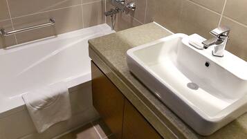 A bathroom with a bathtub, a sink, and a towel rack.