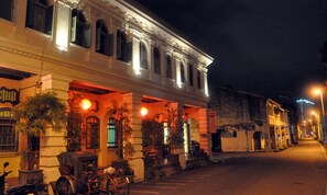 A historic building with a covered entrance, potted plants, and a bicycle parked outside. - Coffee Atelier (George Town)
