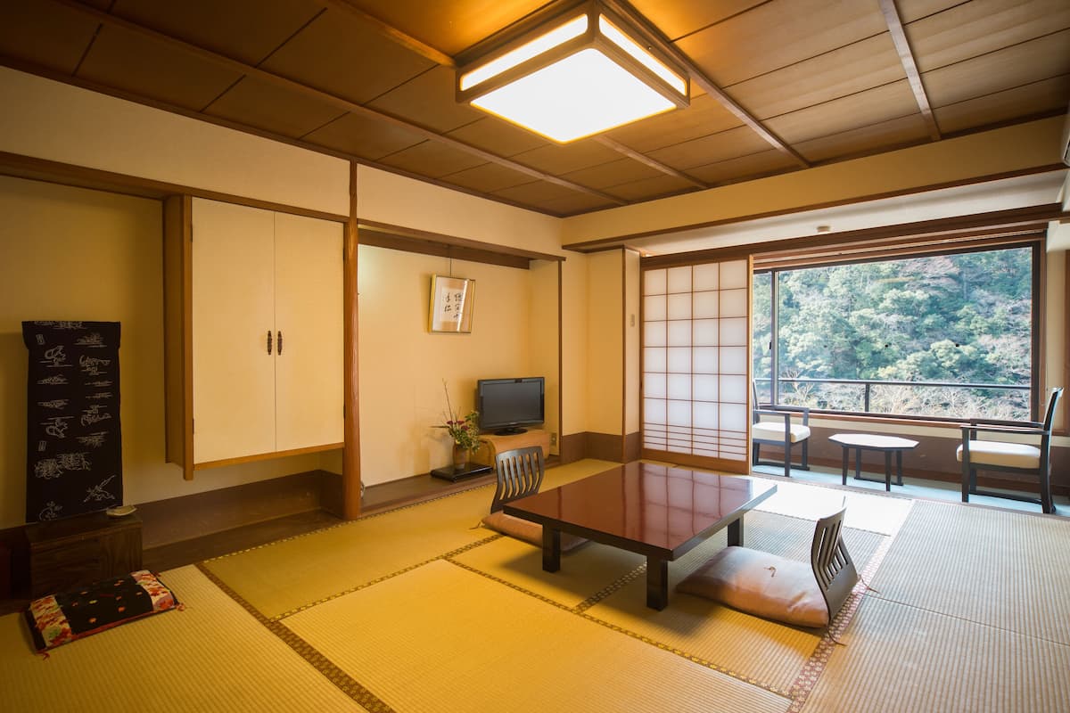 Ett traditionellt japanskt rum med tatamimattor på golvet, ett lågt bord och skjutdörrar.
