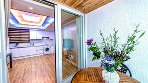 Ett modernt kök med vita skåp, en tvättmaskin och ett tak med färgglad belysning.