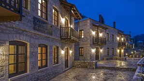 A stone building with a sign reading "Karlokof Summer." - Epoches Luxury Suites (Karpenisi)