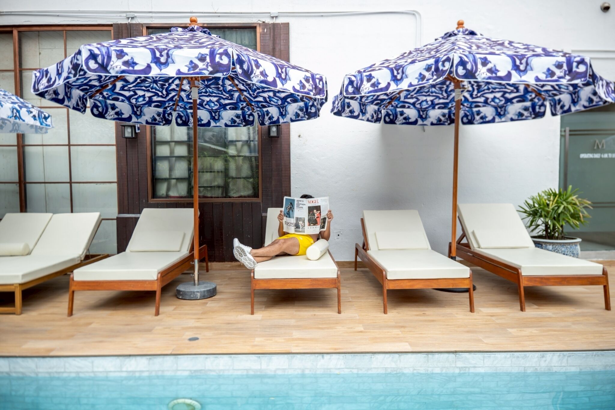 A poolside area with lounge chairs and umbrellas.