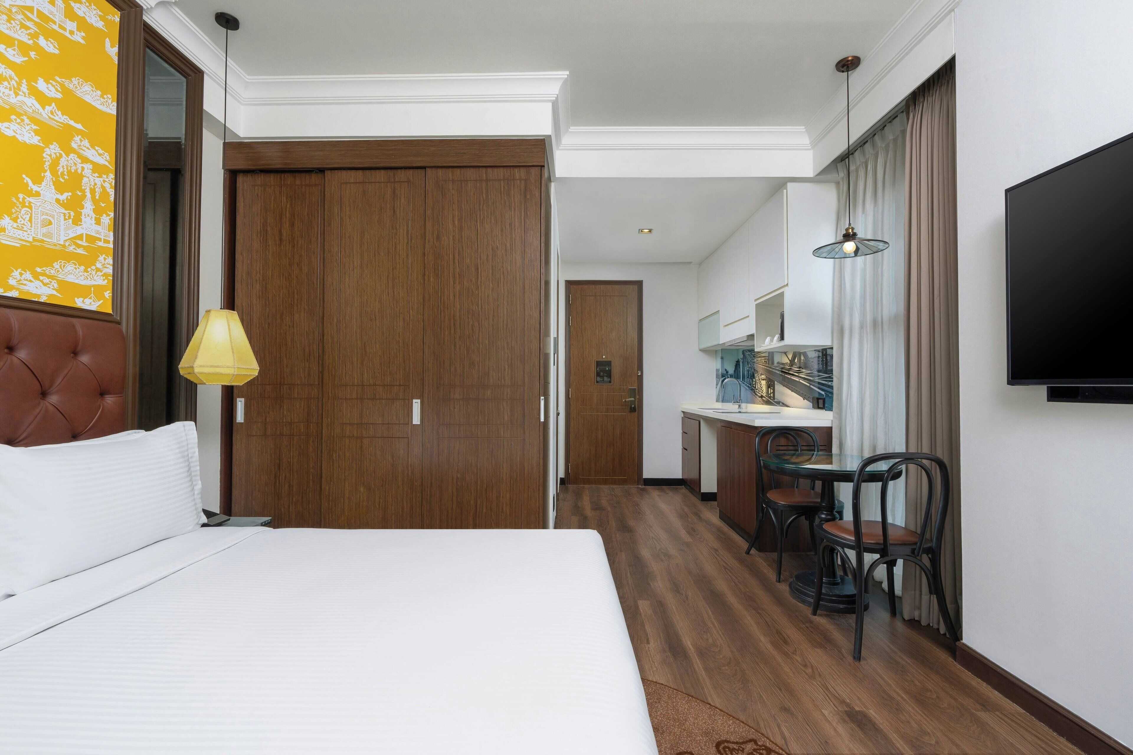 Ein Hotelzimmer mit Bett, Schreibtisch und Fernseher.