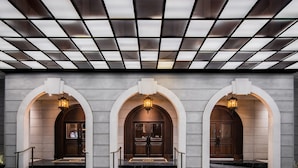 A hotel entrance with three arched doorways, each with a light fixture above. - Metropole, Bangkok, a Tribute Portfolio Hotel (Bangkok)