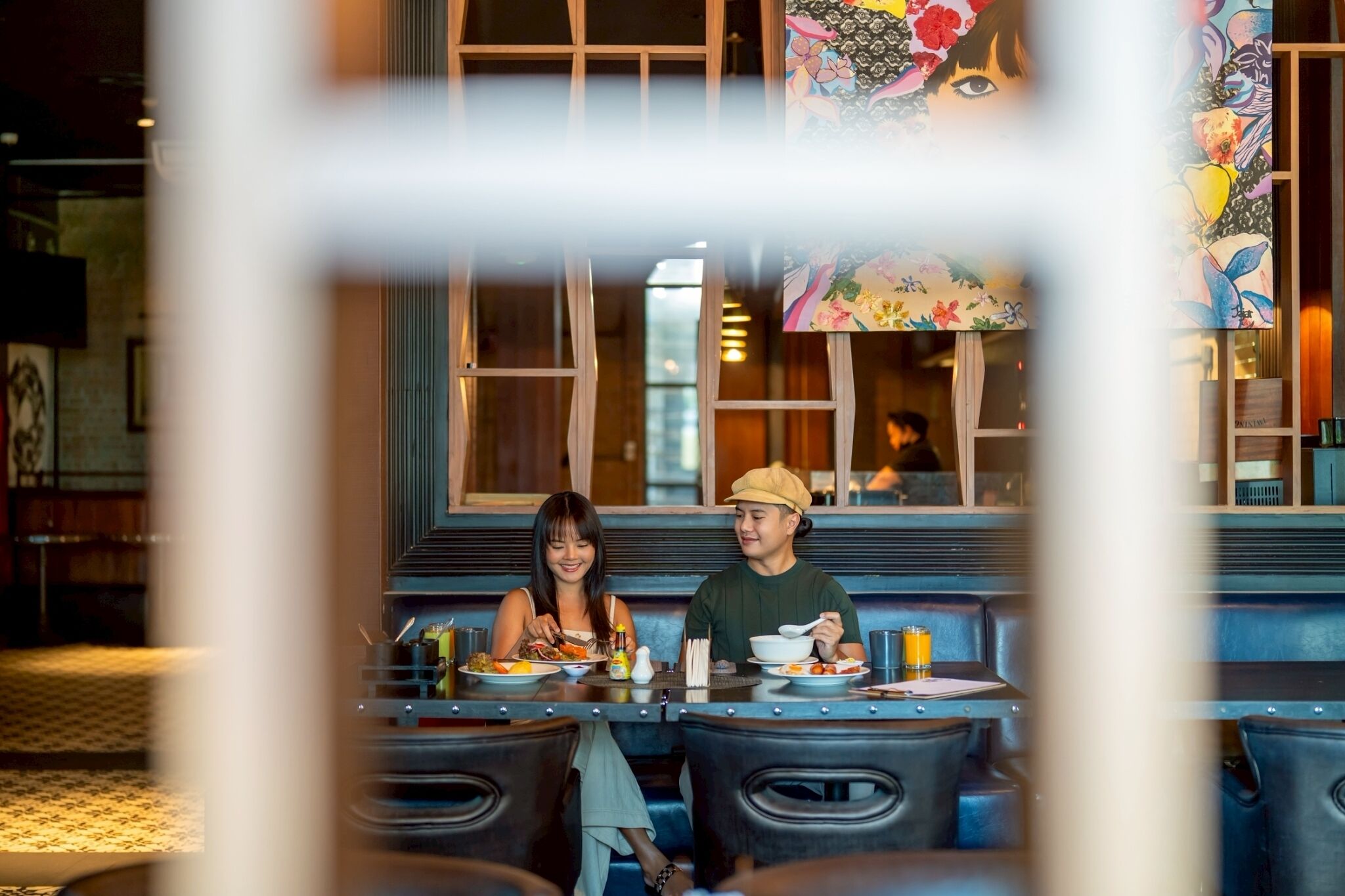 Een restaurantinterieur met een eetgedeelte met tafels en stoelen.