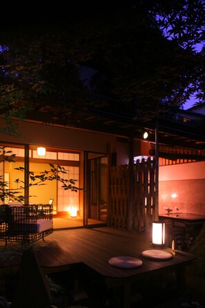 A traditional Japanese-style building with tatami mat flooring, a wooden deck, and a lantern. - Yoshidaya Sannokaku (Kaga)