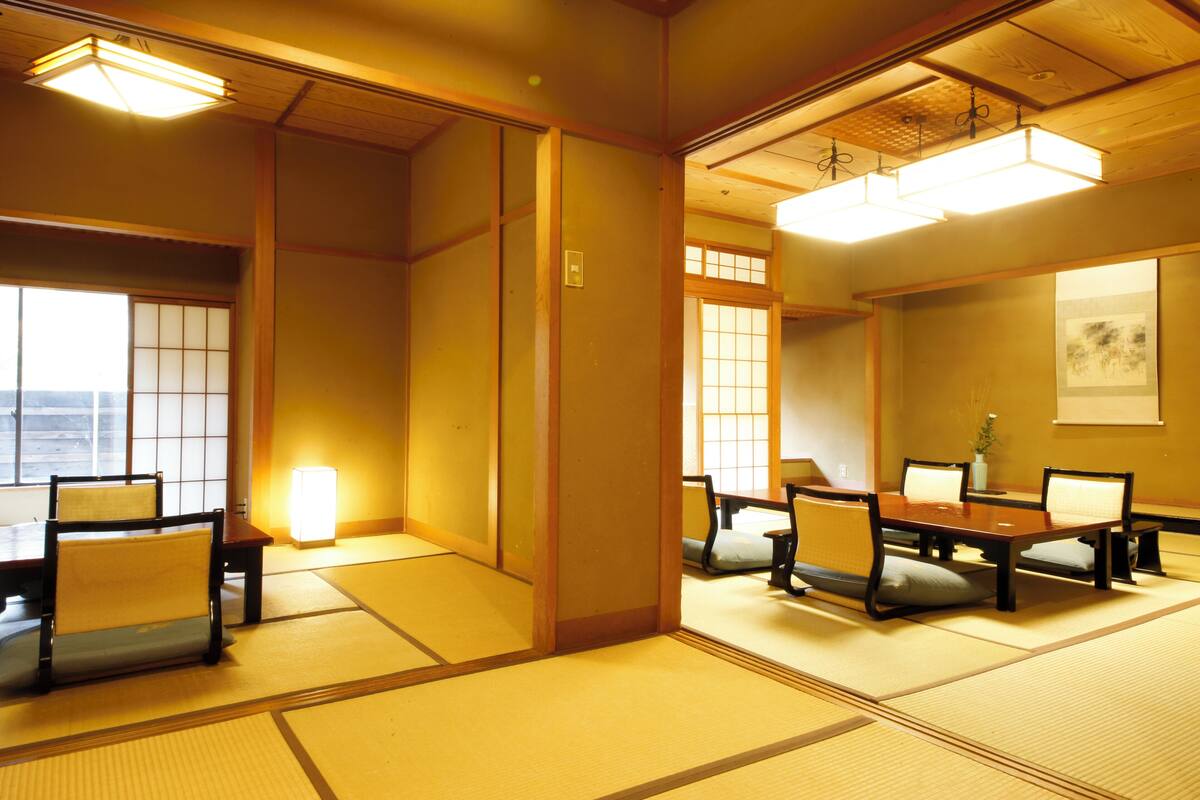 Una habitación japonesa tradicional con suelo de tatami, una mesa baja y sillas.