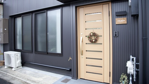 A modern building with a large window, a wooden door with a wreath, and a sign reading "CHELSEA 24 KYOTO". - Chelsea24 Kyoto (Kyoto)