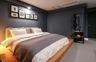 Quarto moderno com uma cama grande, um guarda-roupa com espelho e quadros nas paredes.