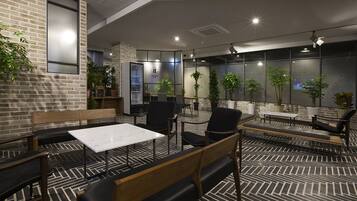 Un área de estar moderna en el interior, con paredes de ladrillo, muebles de madera y plantas en macetas.