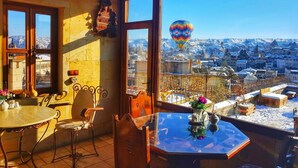 Une pièce chaleureuse avec vue sur un paysage enneigé et un ballon à air chaud.