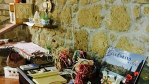 A table with various items including books, a wine brochure, and decorative objects. - B&B Maremma Nel Tufo (Pitigliano)