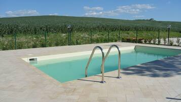 Alberca al aire libre y camastros