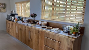 A kitchen with wooden cabinets, a coffee maker, a toaster, and various food items on the counter.