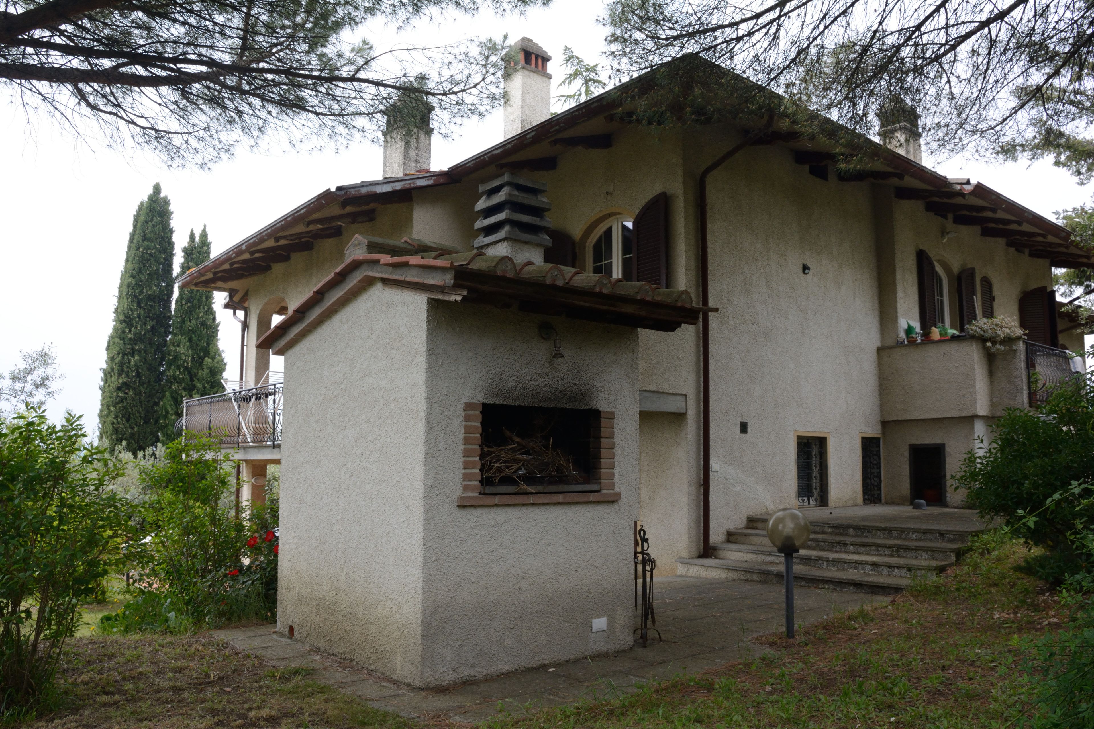 A two-story house with a balcony, a chimney, and a small window.