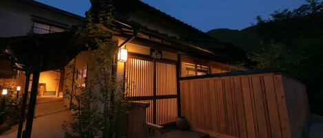 Ein traditionelles japanisches Gebäude mit Holzfassade, einem Schild mit der Aufschrift '33' und einer kleinen Veranda.