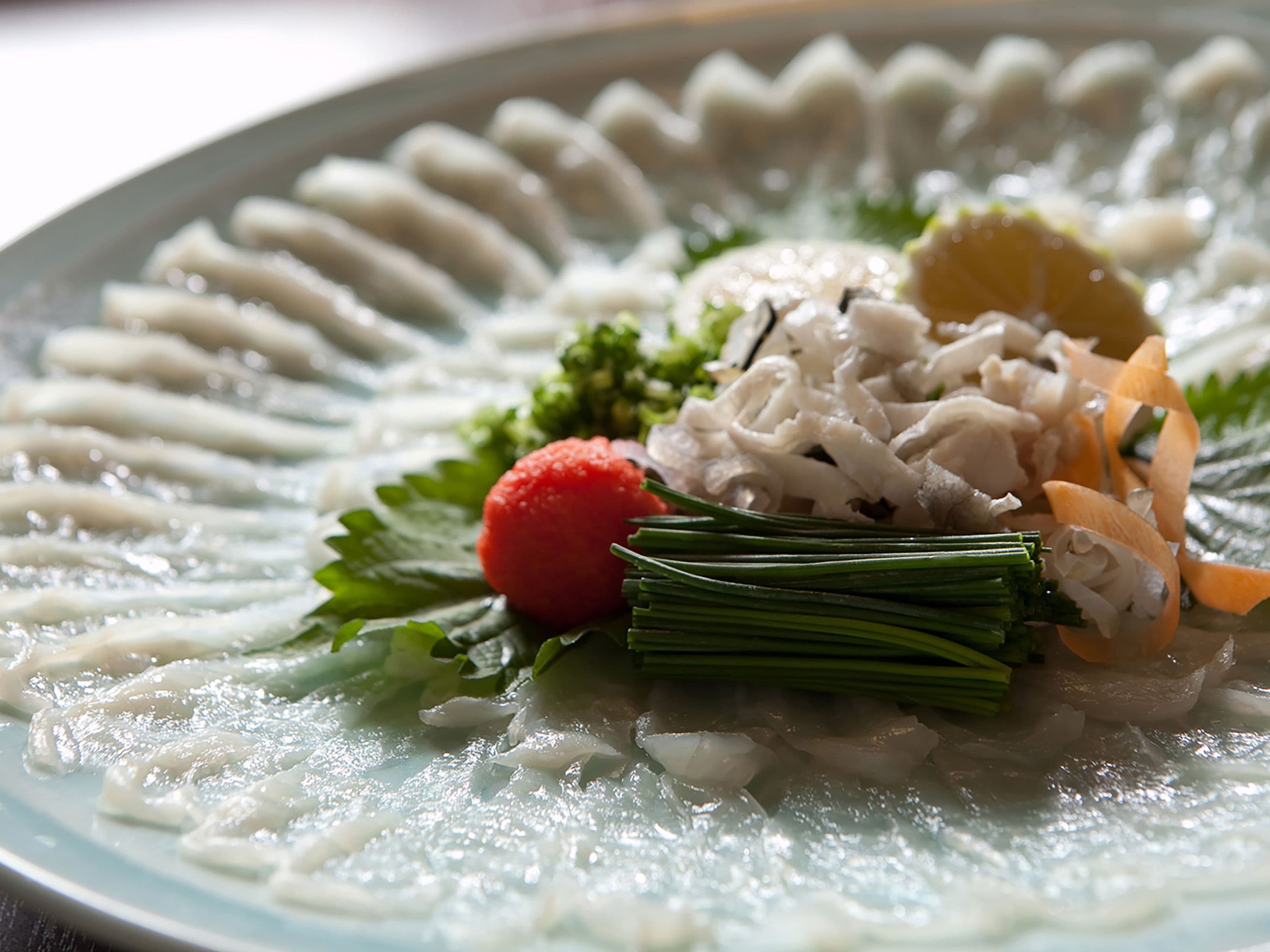 A plate of sashimi with various garnishes.