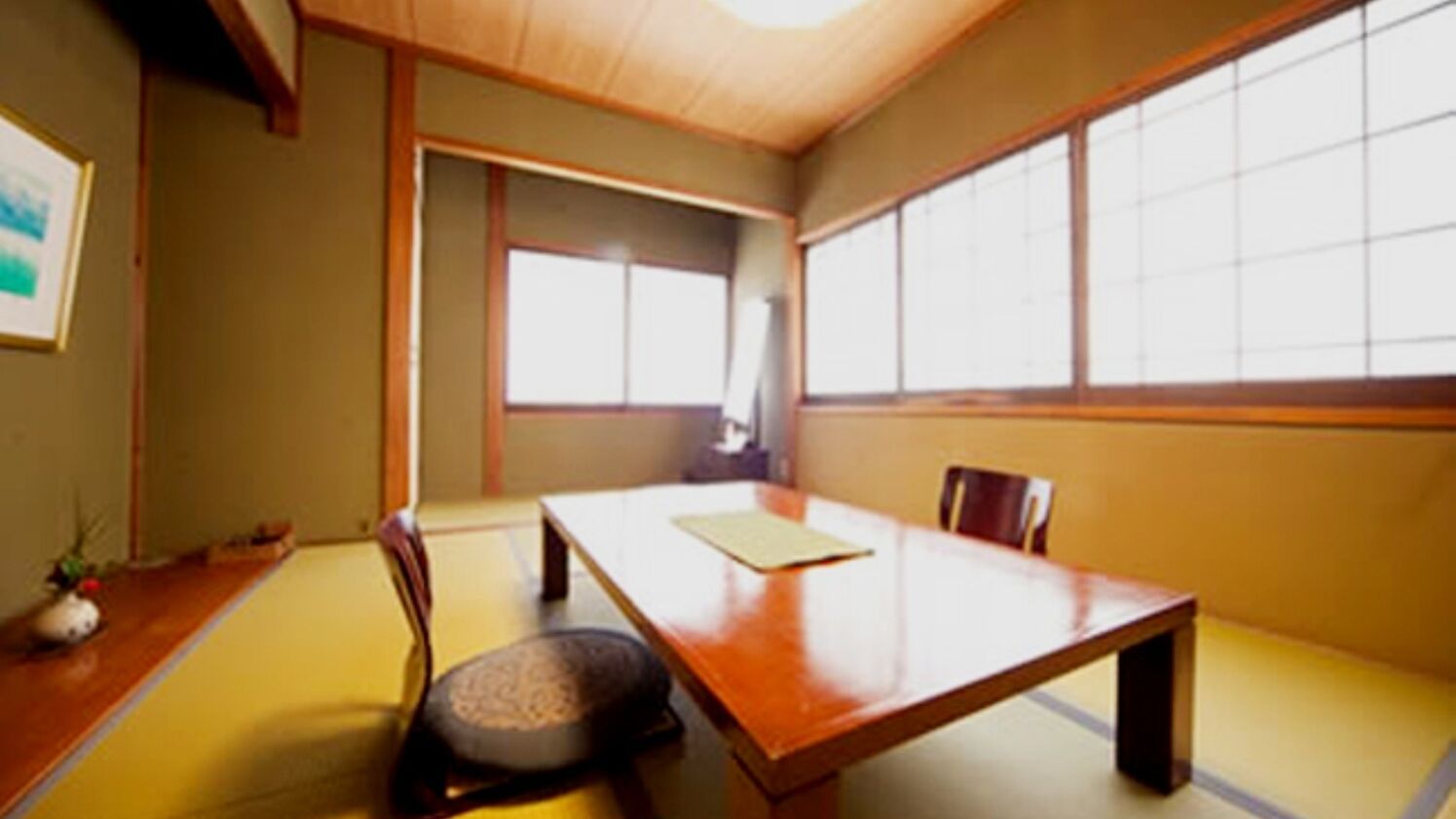 A traditional Japanese-style room with tatami flooring, a low wooden table, and sliding doors.