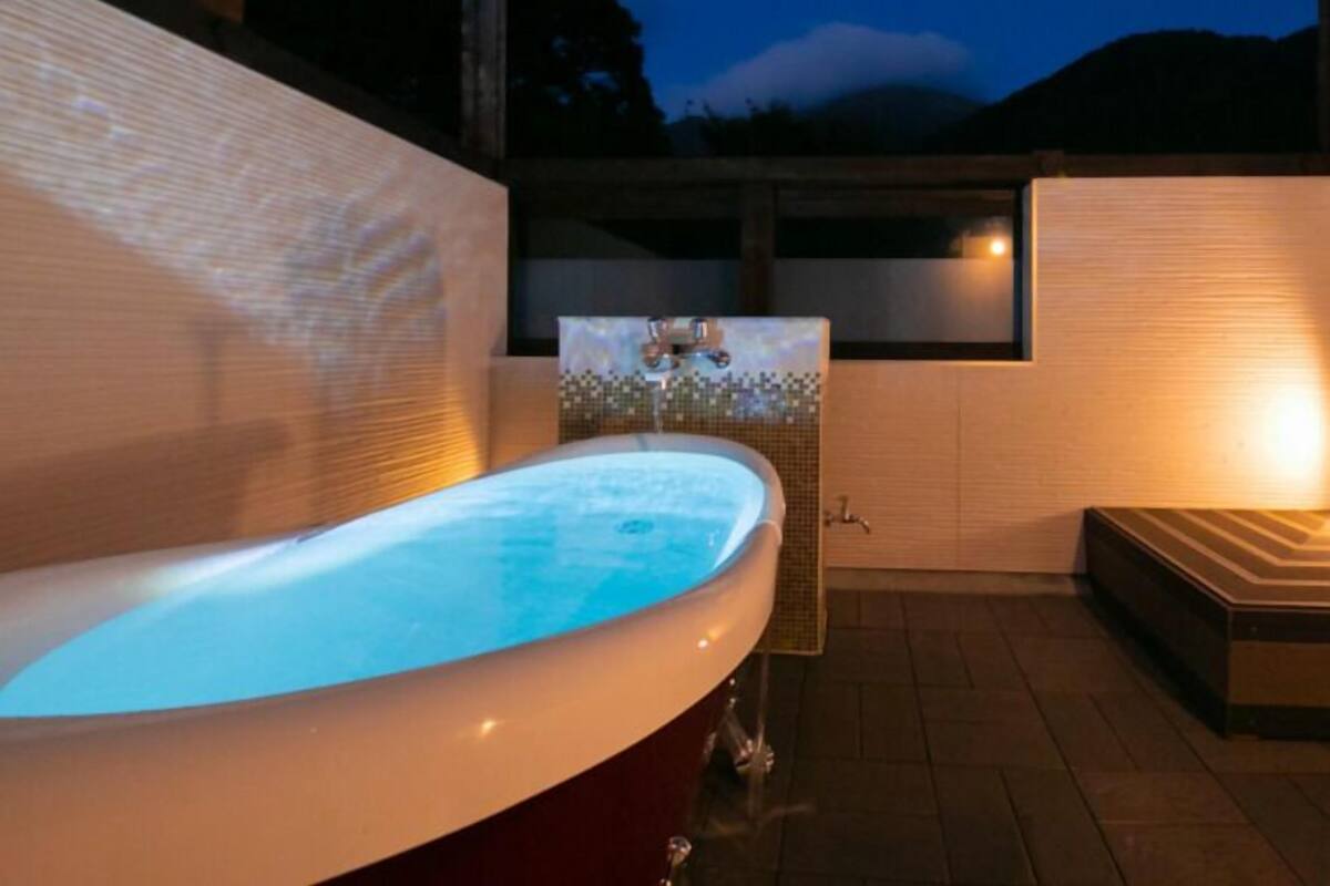 Un jacuzzi con revestimiento de azulejos, una ventana y un banco.