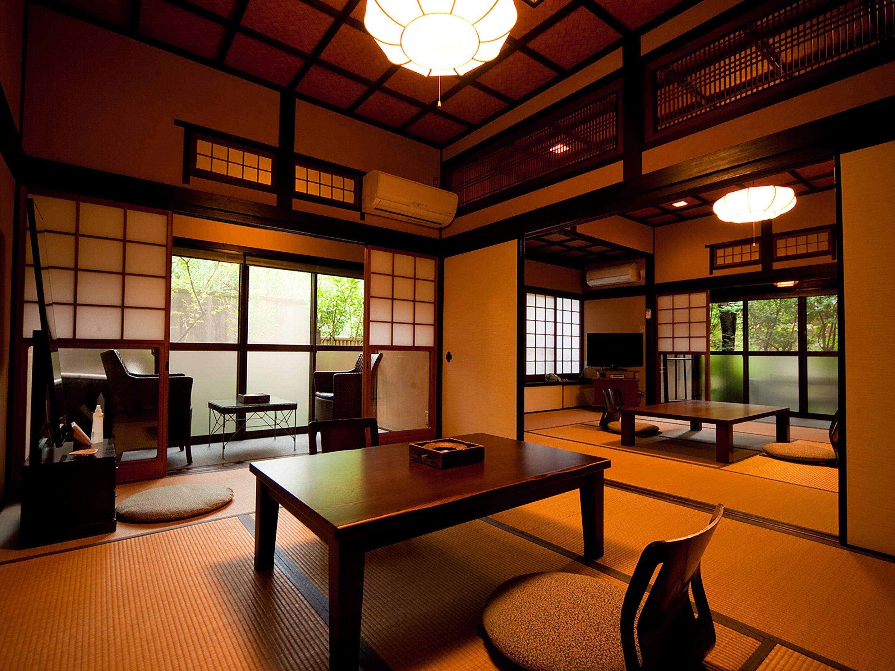 A traditional Japanese room with tatami flooring, a low table, and sliding doors.