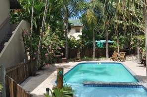 Una piscina al aire libre, tumbonas